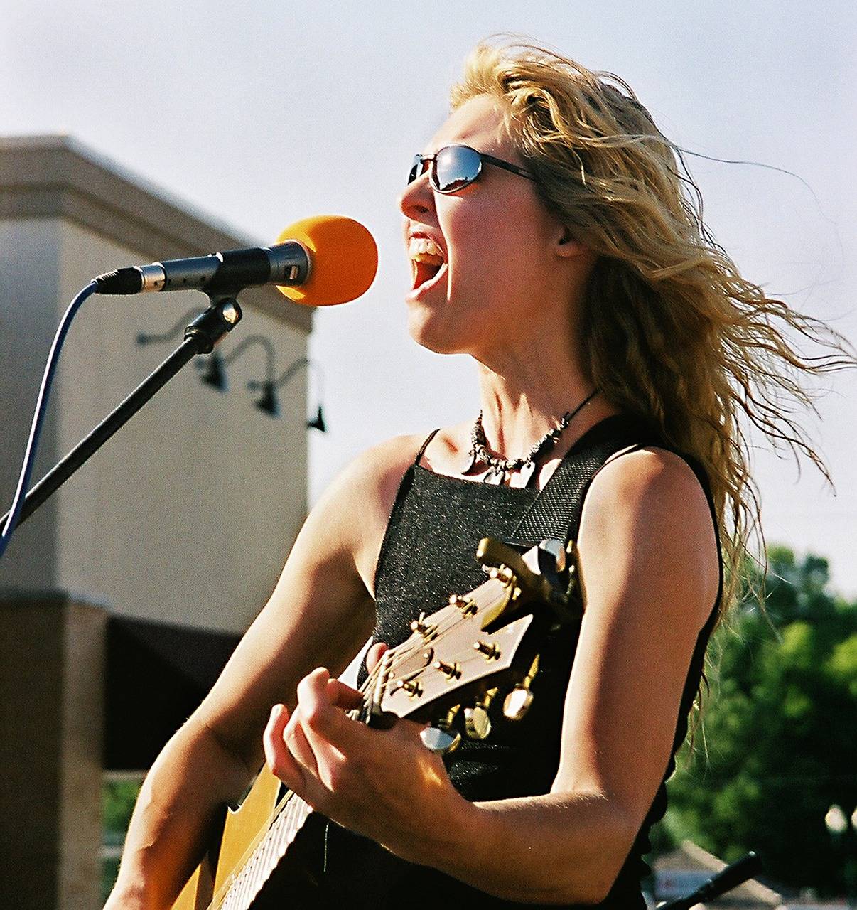 young girl singing and playing guitar on stage
